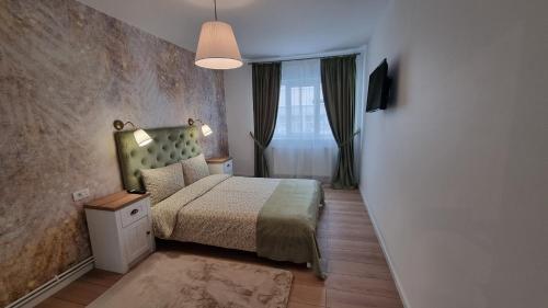 a small bedroom with a bed and a window at Central Residence in Bacău