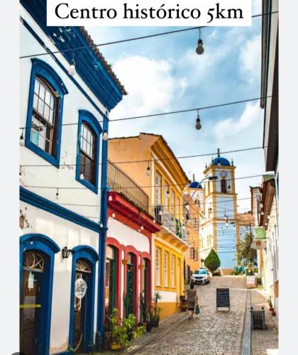 a city street with colorful buildings and a clock tower at Cabana Monte Trigo in São Francisco do Sul