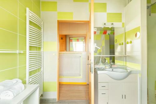 een badkamer met een wastafel en een spiegel bij Les Grands Crus - Meursault in Corpeau