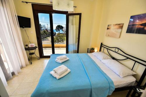 Un dormitorio con una cama azul con toallas. en Guedin Sea Side Maisonette, Nikiti en Nikiti