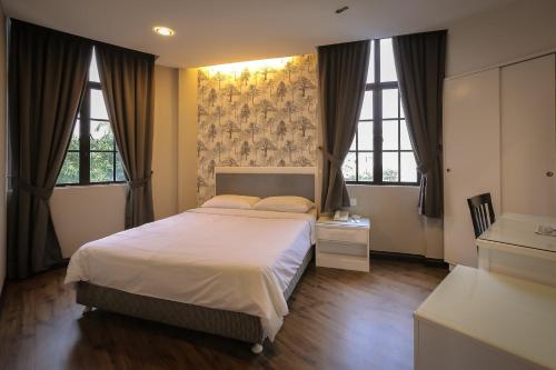 a bedroom with a large bed and two windows at Hotel Ming Star in Kuala Terengganu