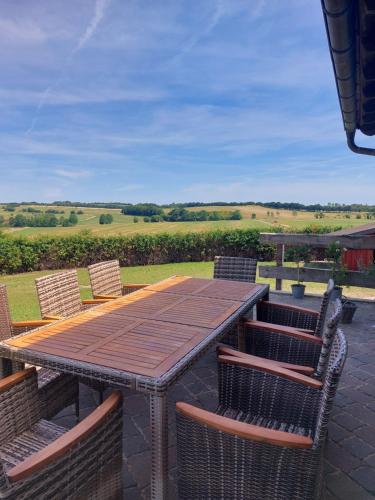 a wooden table and chairs on a patio at Haus Eufalia in Blankenheim