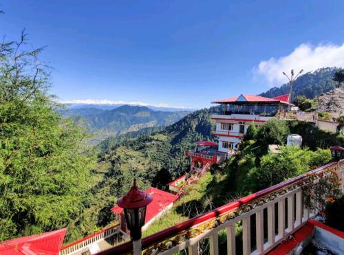 un edificio en una colina con vistas a las montañas en Hotel Mount View Dhanaulti Dreams en Dhanaulti