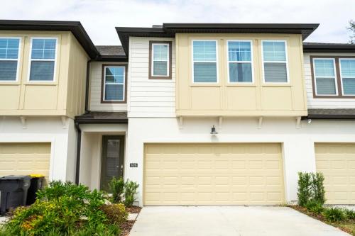 a house with two garage doors in front of it at Cozy 3 Bd Close to Disney @ Enclaves at Festival 808 in Davenport