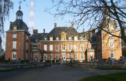 un gran edificio de ladrillo con una torre encima en Aparthotel Domaine du Chateau de la Neuville en Tihange