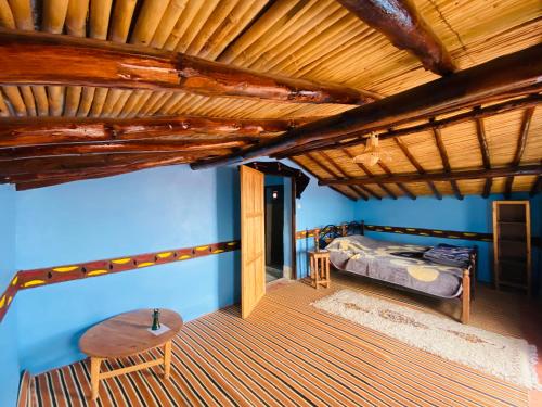 a bedroom with a bed and a wooden ceiling at Desert Tours & Camp Chraika in Mhamid