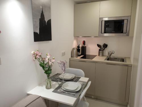 une cuisine avec une table avec un vase de fleurs dessus dans l'établissement STUDIO NEUF ET CHARMANT VIEIL ANTIBES, à Antibes