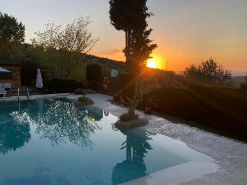 a swimming pool with the sunset in the background at Cabañas De Madera Y Bungalows - Gilmañas 3 in La Iruela