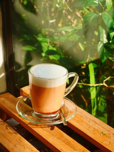 a cup of coffee sitting on a wooden table at Cửa Biển Homestay in Hai Phong