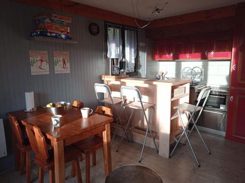 - une cuisine avec un comptoir en bois, une table et des chaises dans l'établissement Appartement idéal pour une famille., à Praz-sur-Arly