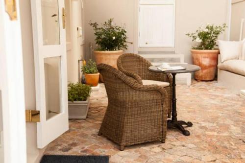 a living room with wicker chairs and a table at 33 Strawberry Lane - Studio and Cottage in Cape Town