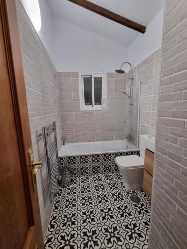 La salle de bains est pourvue de carrelage noir et blanc. dans l'établissement Lovely 2 Bed Apartment with Stunning views & Pool, à Cómpeta
