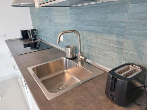 a stainless steel sink in a small kitchen at Domo Allegru in Torre Dei Corsari