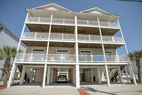un gran edificio blanco con un coche aparcado delante de él en Grand Cayman Villas by Coastline Resorts, en Myrtle Beach