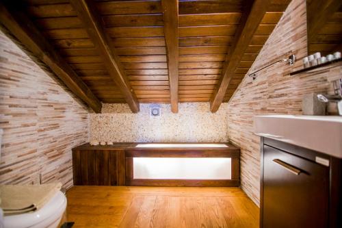 a bathroom with a toilet and a wooden ceiling at Villa Kasta in Kavála