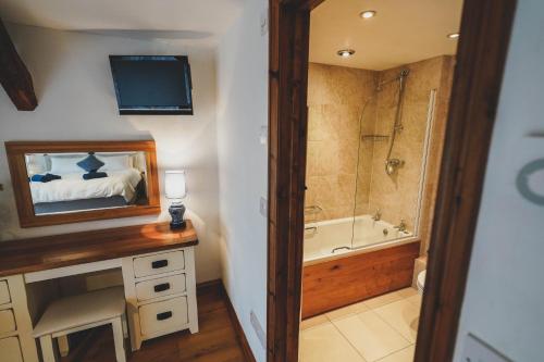 a bathroom with a bed and a tub and a television at Hawley Farm in Hawley Bottom