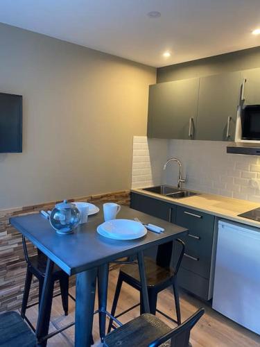 une cuisine avec une table bleue, des chaises et un évier dans l'établissement Résidence Le Kandahar BAT B N 209 Parking, à Les Deux Alpes
