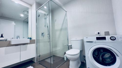 a bathroom with a toilet and a washing machine at Stylish Southbank apartment Plus Free Parking for 2 Cars in Melbourne