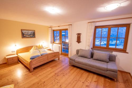 a bedroom with a bed and a couch at Patztauhof in Sluderno