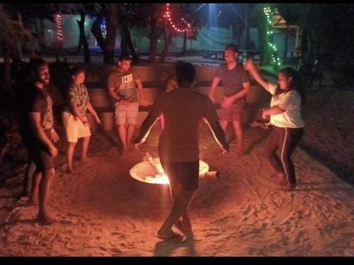 a group of people playing with a frisbee at His Grace Camping at Malpe Beach in Udupi