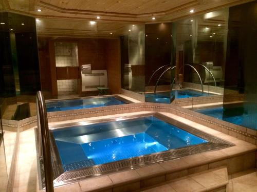 a large bathroom with two blue jacuzzi pools at Aux Ducs de Savoie in Combloux