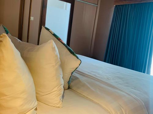 un letto con cuscini bianchi in una stanza con finestra di Anchor Bed & Bread a Kuta Lombok