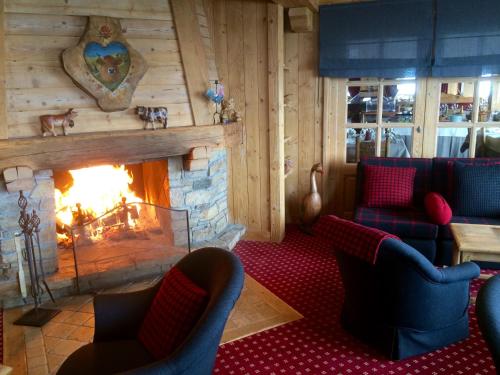 a living room with a fireplace and couches at Aux Ducs de Savoie in Combloux