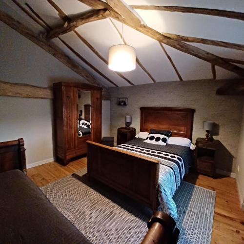 a bedroom with a large bed with a wooden headboard at Le Figuier in Le Lindois