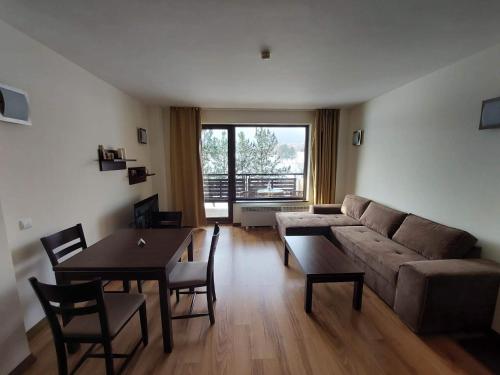 uma sala de estar com um sofá e uma mesa em The View Apartment, Terra Complex neighbour building em Bansko