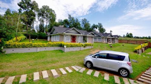 a small car parked in front of a house at Lamanis Haven in Kakamega
