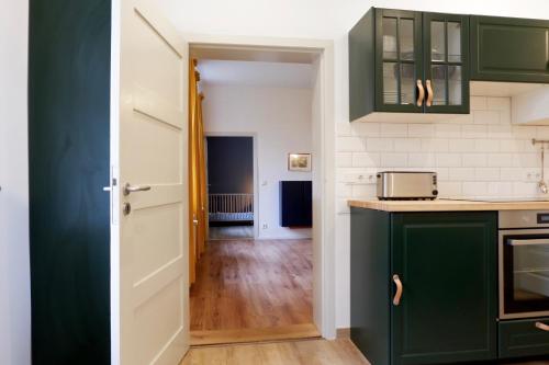 a kitchen with green cabinets and a hallway at Gut Boltenhof in Fürstenberg-Havel