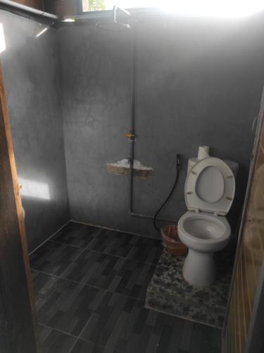 - une petite salle de bains avec toilettes dans une cabine dans l'établissement Air Manis Secret Surfcamp, à Taluk Batung