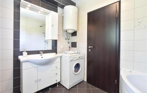 uma casa de banho com uma máquina de lavar roupa e um lavatório em Pet Friendly Apartment In Split With Kitchen em Split