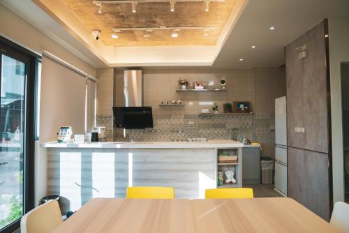 a kitchen with a table and yellow chairs at Flower Garden B&B in Hengchun