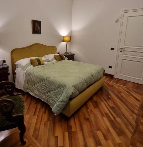 a bedroom with a bed and a wooden floor at L'Arnia in Naples