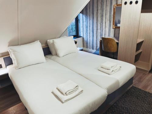 une chambre d'hôtel avec un lit et des serviettes. dans l'établissement Hello Zeeland - Appartement Duno Lodges 6 personen, à Oostkapelle