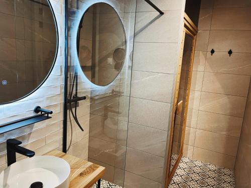La salle de bains est pourvue d'un lavabo et d'une douche. dans l'établissement Hello Zeeland - Appartement Duno Lodges 6 personen, à Oostkapelle