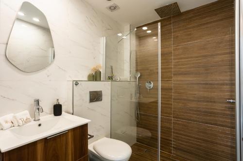 een badkamer met een douche, een toilet en een wastafel bij YalaRent Flora- Designed 1BR penthouse in Florentin in Tel Aviv