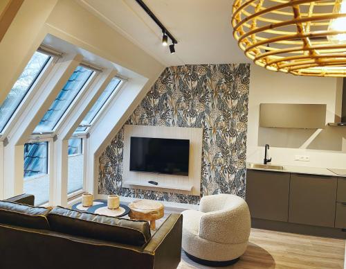 a living room with a couch and a tv at Hello Zeeland - Appartement Duno Lodge L in Oostkapelle