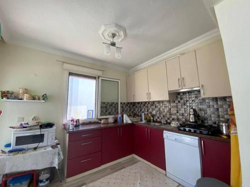 a kitchen with red cabinets and a window at Inviting 2-Bed House in Mugla in Gumusluk