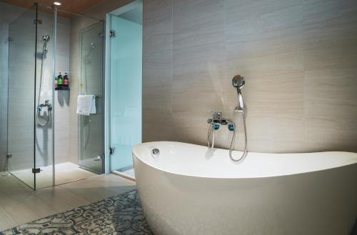 La salle de bains est pourvue d'une baignoire et d'une douche. dans l'établissement Flower Garden B&B, à Hengchun Old Town