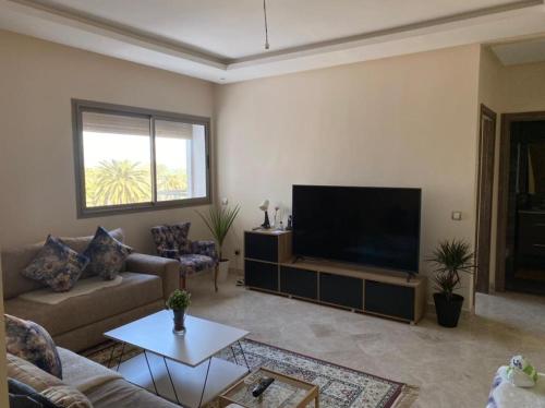a living room with a large flat screen tv at Le Joyau Cosy Home in Mohammedia