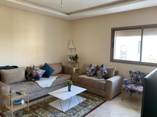 sala de estar con sofá y mesa en Le Joyau Cosy Home en Mohammedia