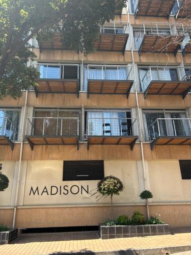 un bâtiment avec un panneau madison sur son côté dans l'établissement Joburg’s Cutest Condo., à Johannesbourg