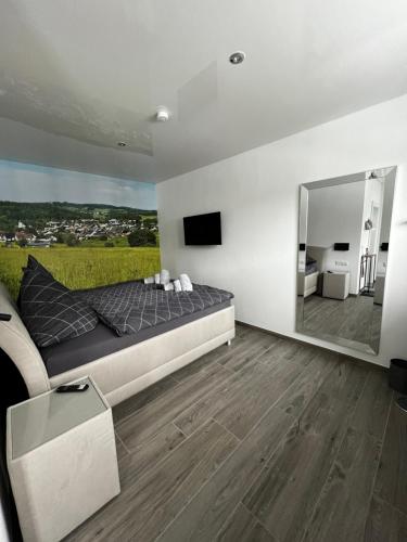 a bedroom with a large bed and a mirror at Haus Maensel in Kelberg