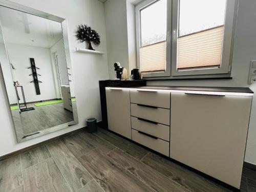 a bathroom with a large mirror and a sink at Haus Maensel in Kelberg