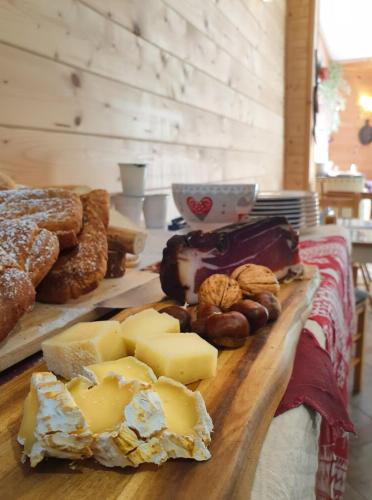 a table topped with different types of cheese and pastries at Villa Amaranta Room and Breakfast in Edolo