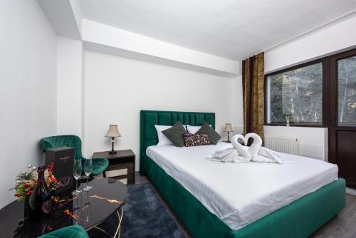 a bedroom with a bed with two swans on it at Pensiunea Ursuletul Paddington in Predeal