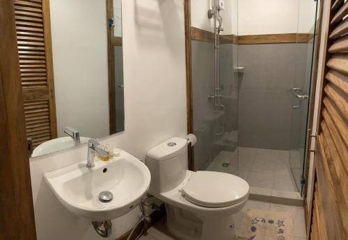 a bathroom with a toilet and a sink and a shower at P&B Residences Legazpi in Legazpi