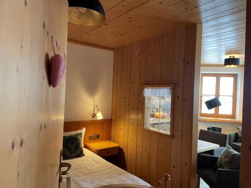 a bedroom with wooden walls and a bed in a room at Landhaus in Balderschwang